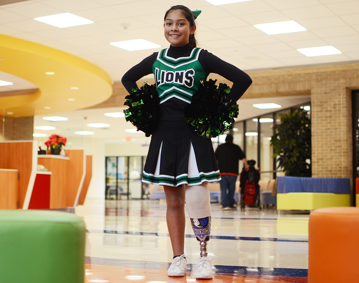 Young girl with prosthetic leg in cheerleading uniform at Texas Scottish Rite Hospital for Children
