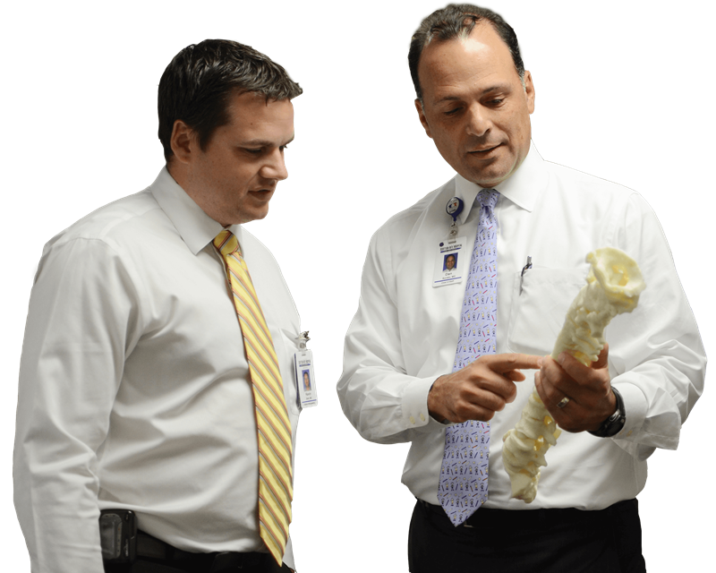 Orthopedic spine surgeon using a model spine to train another doctor at Texas Scottish Rite Hospital for Children 